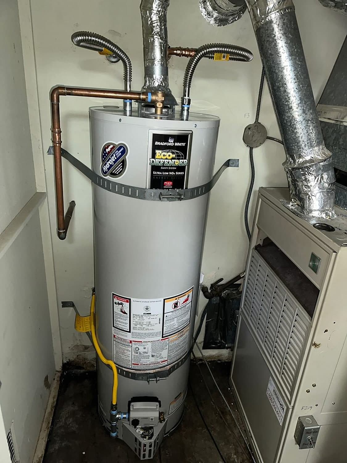 Bradford White water heater in a closet with a new yellow gas line, new copper supply lines and seismic straps