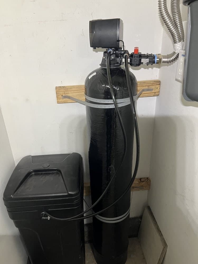 Water softener resin tank and brine tank installed in a utility corner